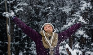 Women in snow with hands raised